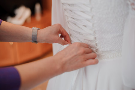 A Bride's Preparations: Adjusting the Laces of a Stunning Wedding Gown.の写真素材