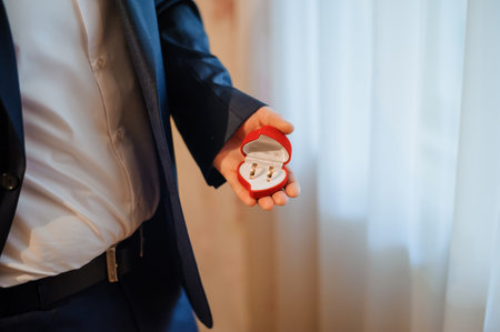 Elegant Ring Ceremony with Glistening Diamond Rings in a Stylish Red Box.の写真素材