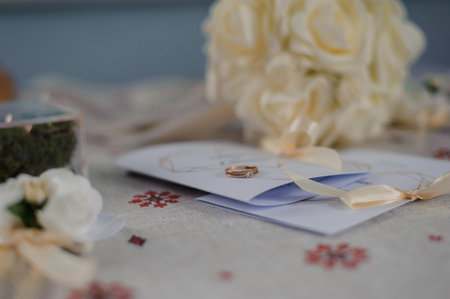 Elegant Wedding Details Featuring a Rose Gold Ring, Invitation, and Floral Accents.の写真素材
