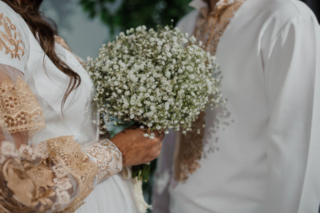 Elegant Bride Holding a Delicate Baby's Breath Bouquet in a Romantic Setting.の写真素材