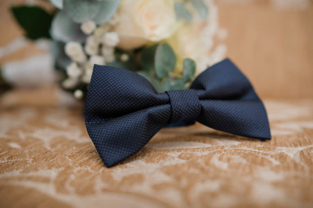 Elegant Navy Bow Tie on Vintage Lace Table Setting with Floral Arrangement.の写真素材