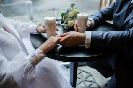 Romantic Moment: Wedding Couple Holding Hands Over Coffee.の写真素材