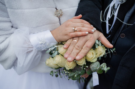 Intimate Wedding Moment with Hands and Bouquet of Roses.
