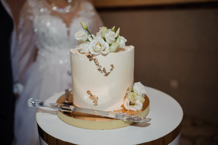 Elegant Wedding Cake Decorated with White Roses and Gold Accents.の写真素材