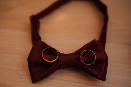 Elegant Burgundy Bow Tie with Wedding Rings.の写真素材