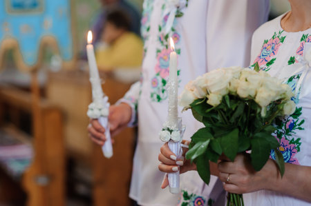 Elegant Wedding Ceremony with Candles and Bouquet in Traditional Attire.の写真素材
