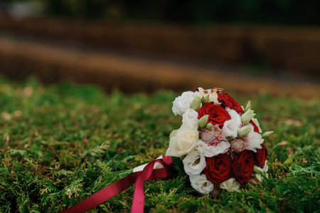 Elegant Bridal Bouquet with Gold Rings on Grass.の写真素材