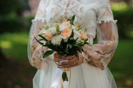 Elegant Bride Holding a Charming Bouquet in a Lush Garden.の写真素材