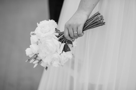 Elegant Bride Holding a White Flower Bouquet with Wedding Ring.の写真素材
