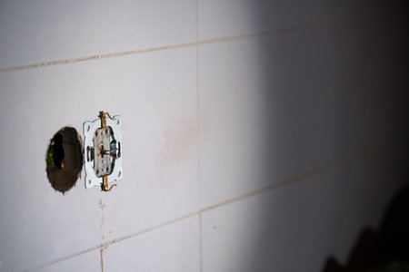 Electrical Outlet Installation with Exposed Wiring in a Tiled Wall.の写真素材