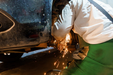Mechanic Welding Underneath a Vehicle with Sparks Flying.