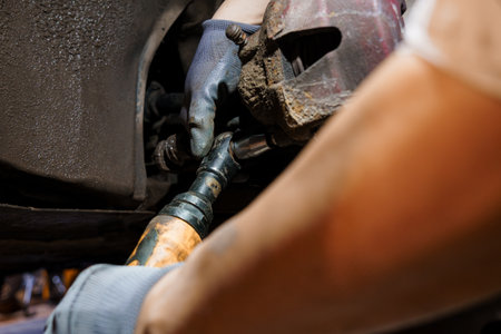 Detailed Close-up of a Mechanic Working on Car Brakes with Tools.の写真素材