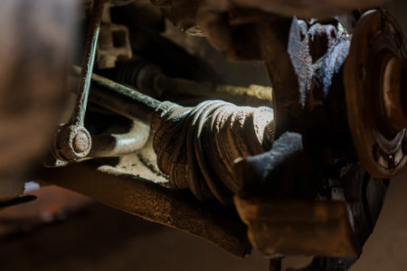 Detailed Close-Up of a Car's Suspension System Components in Dim Lighting.の写真素材