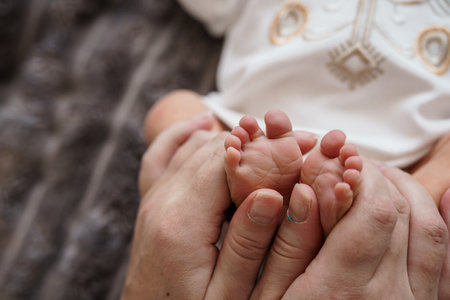 A Tender Moment: Newborn Baby Feet Held by Loving Parent.