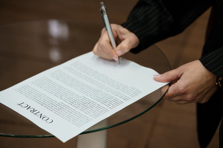 Hand Signing a Legal Contract on a Glass Table.