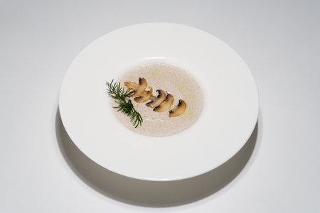 Elegant Gourmet Creamy Mushroom Soup Decorated with Herbs in White Bowl.の写真素材