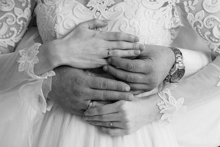 Intimate Wedding Moment: Hands Interlocked with Rings Symbolizing Love and Commitment in a Black and White Portrait.の写真素材
