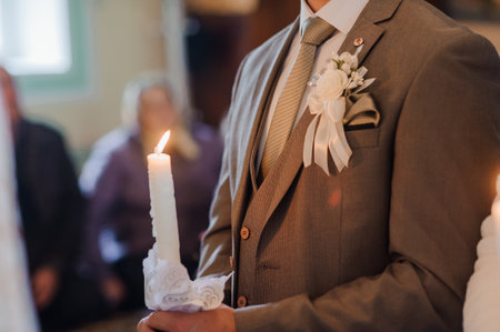 A close-up photograph showcasing a young groom participating in an Orthodox wedding ceremony he...