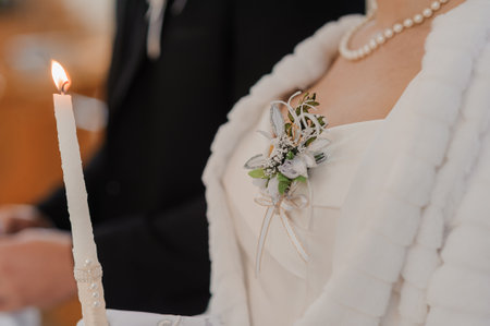Intimate view of a wedding candle ceremony with a bride wearing a white fur stole and pearl necklace groom in formal attire, symbolizing unity and faithの写真素材