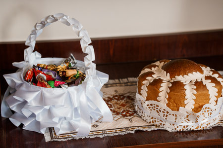 A beautifully arranged still life showcases a round Easter bread adorned with white lace and a...