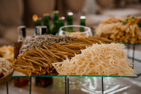 An upscale catering spread art features fully arranged dried fish and colorful vegetable crudites displayed on glass platters at a sophisticated event, inviting guestsの写真素材