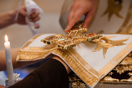 Beautiful moment during an Orthodox wedding with a priest blessing the bride and groom with a ornate...