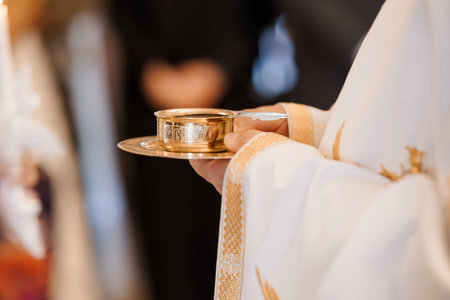 Religious scene of a priest offering the Eucharist during a Catholic mass. golden chalice with host...