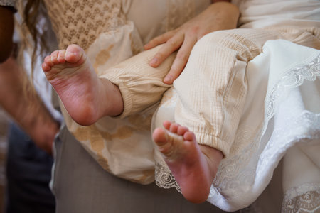 A close-up, soft-focus photograph showcases tiny baby feet being held lovingly, wearing ribbed tan...