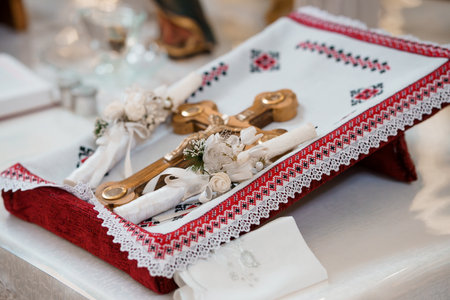 A beautifully arranged Orthodox Christening set with a silver cross, white wax candles, embroidered...