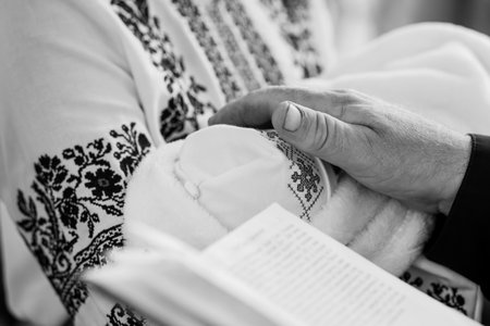 A touching black and white photo depicts a man's hand gently holding the foot of a small baby while...
