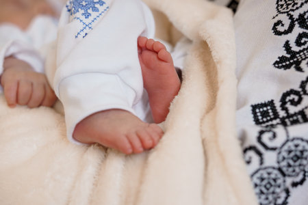 A heartwarming close-up captures tiny newborn baby feet gently enveloped in a soft, creamy white...