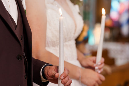 Orthodox Wedding Ceremony Candles Lighting with Bride and Groom in Church, Warm Tone, Traditional Celebration, Rich Burgundy Detail.の写真素材