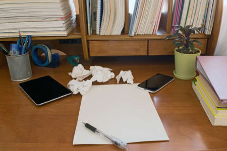 Pen on notebook, mobile paper was crumpled on the wooden table