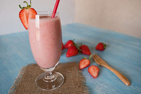 Fresh strawberry healthy milkshake on blue wooden blackground. Strawberry Helthy Smoothie.の写真素材