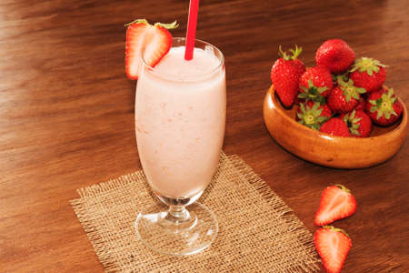 Strawberry healthy milkshake with fresh berries on wooden blackground. Strawberry Helthy Smoothie.の写真素材