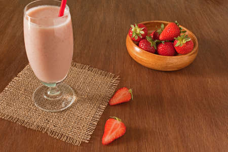 Strawberry healthy milkshake with fresh berries on wooden blackground. Strawberry Helthy Smoothie.の写真素材