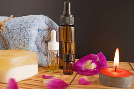 Spa and wellness setting with natural soap and orchid, candles, massage oils and soft towel.の写真素材