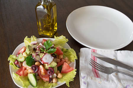 Healthy salad with octopus, chickpeas and vegetables avocado tomato cucumber dill parsleyの写真素材