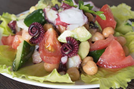 Healthy salad with octopus, chickpeas and vegetables avocado tomato cucumber dill parsleyの写真素材