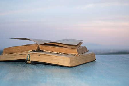 Open books on the wooden blue table the background of the beautiful skyの写真素材
