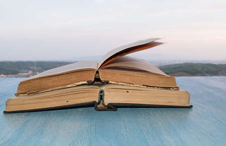Open books on the wooden blue table the background of the beautiful skyの写真素材