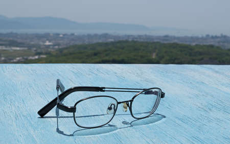 Glasses on the wooden blue table background of the beautiful skyの写真素材