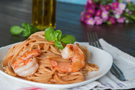 Spaghetti in tomato sauce. Romantic dinner with wine and flowers, asters conceptの写真素材