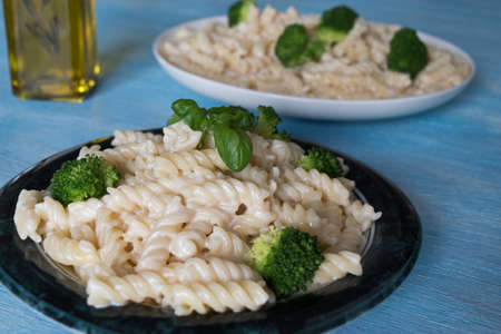 Delicious pasta on plate with broccoli on blue wooden backgroundの写真素材