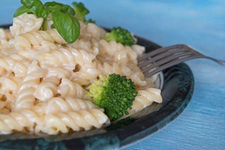 Delicious pasta on plate with broccoli on blue wooden backgroundの写真素材