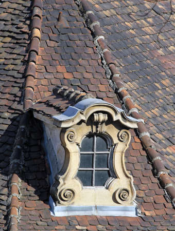 weathered old ornate dormer windows and roof tiles.の写真素材