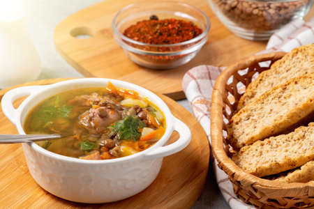 Lentil soup with chicken in a white bowl on a wooden boardの写真素材