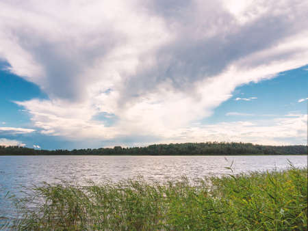 Beautiful clouds in the blue sky over the lakeの写真素材