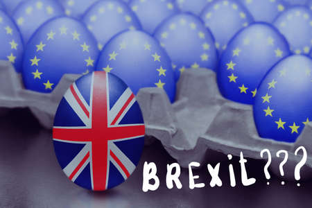 Concept of Brexit is presented from jumping egg with a British flag out of the box with eggs with the flag of the European Union and Brexit inscribed with question marksの写真素材