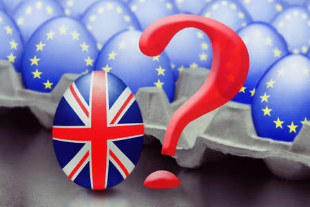 Concept of Brexit is presented from jumping egg with a British flag out of the box with eggs with the flag of the European Union and question markの写真素材